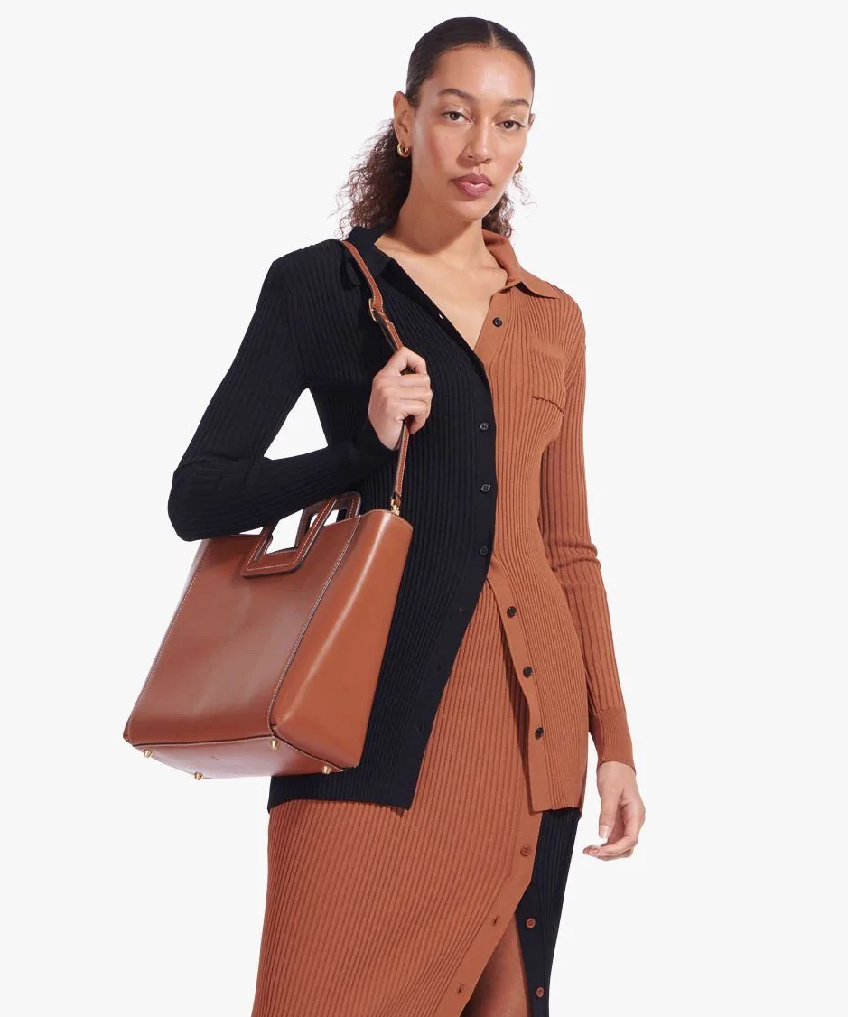 woman holding brown staud bag