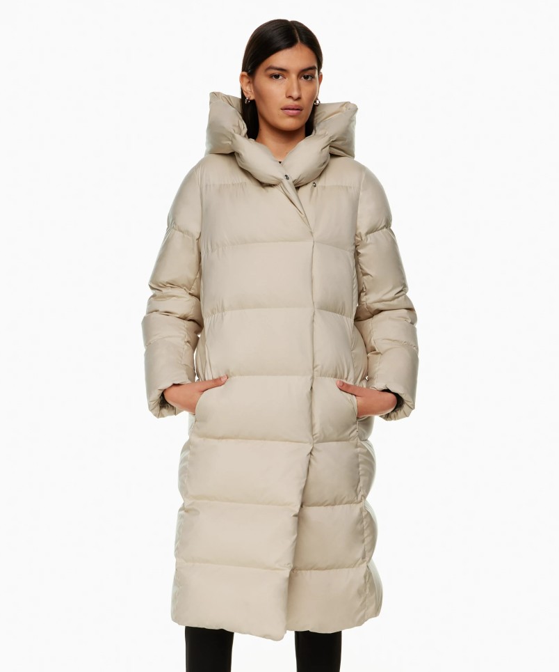 Image of a model wearing a beige Aritzia quilted down jacket
