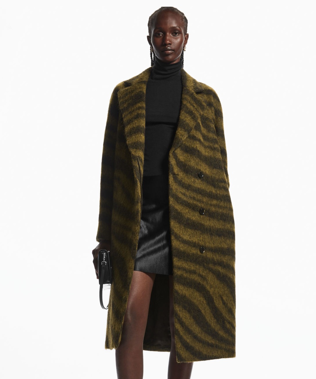 Image of a model wearing a black turtleneck, a black skirt and a muted zebra print wool Cos coat