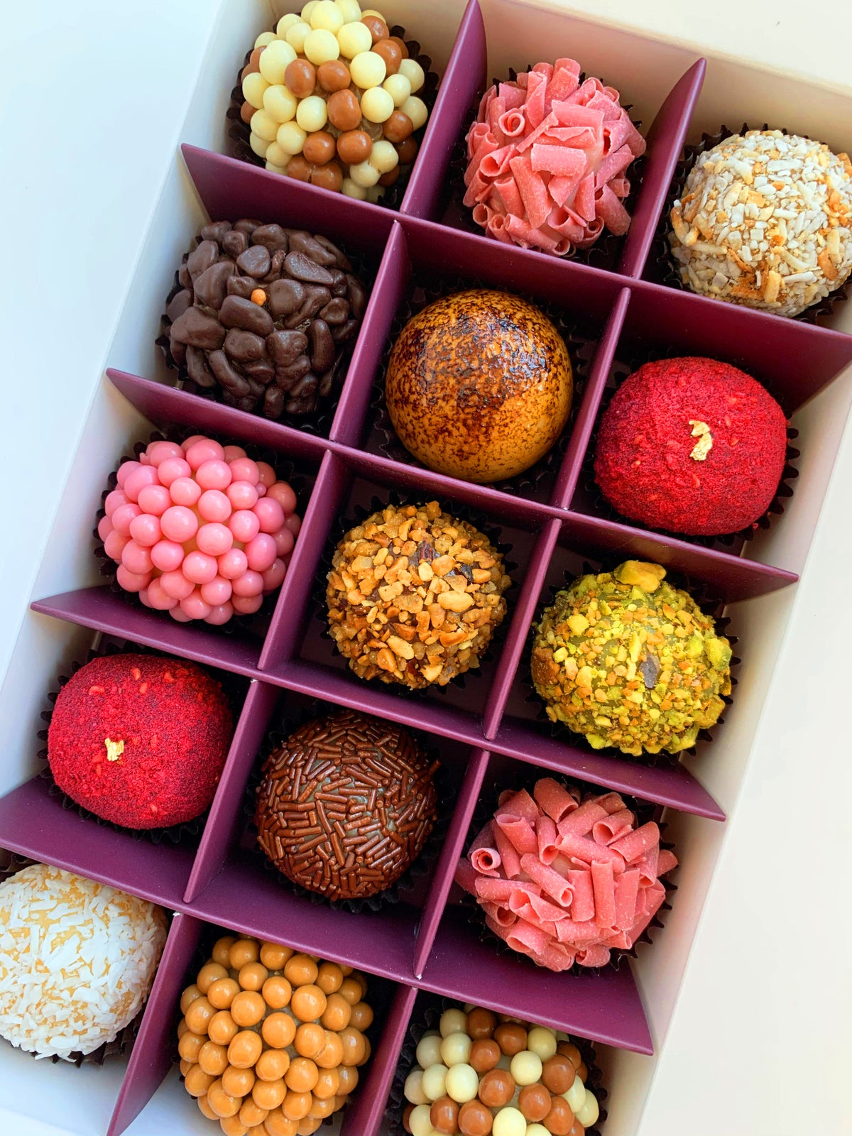 close-up image of assorted, colourful truffles in a box