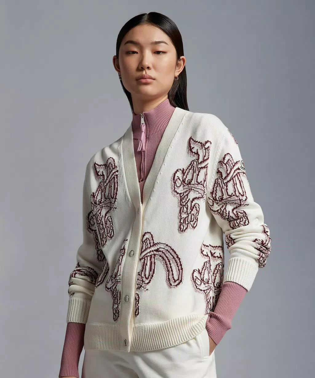 Image of a model wearing a white Moncler cardigan with red rabit motifs throughout. She wears a red and white shirt underneath.