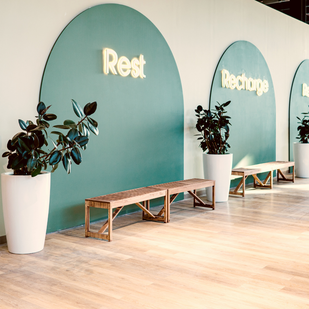 Wall that says "Rest" with a bench in front of it