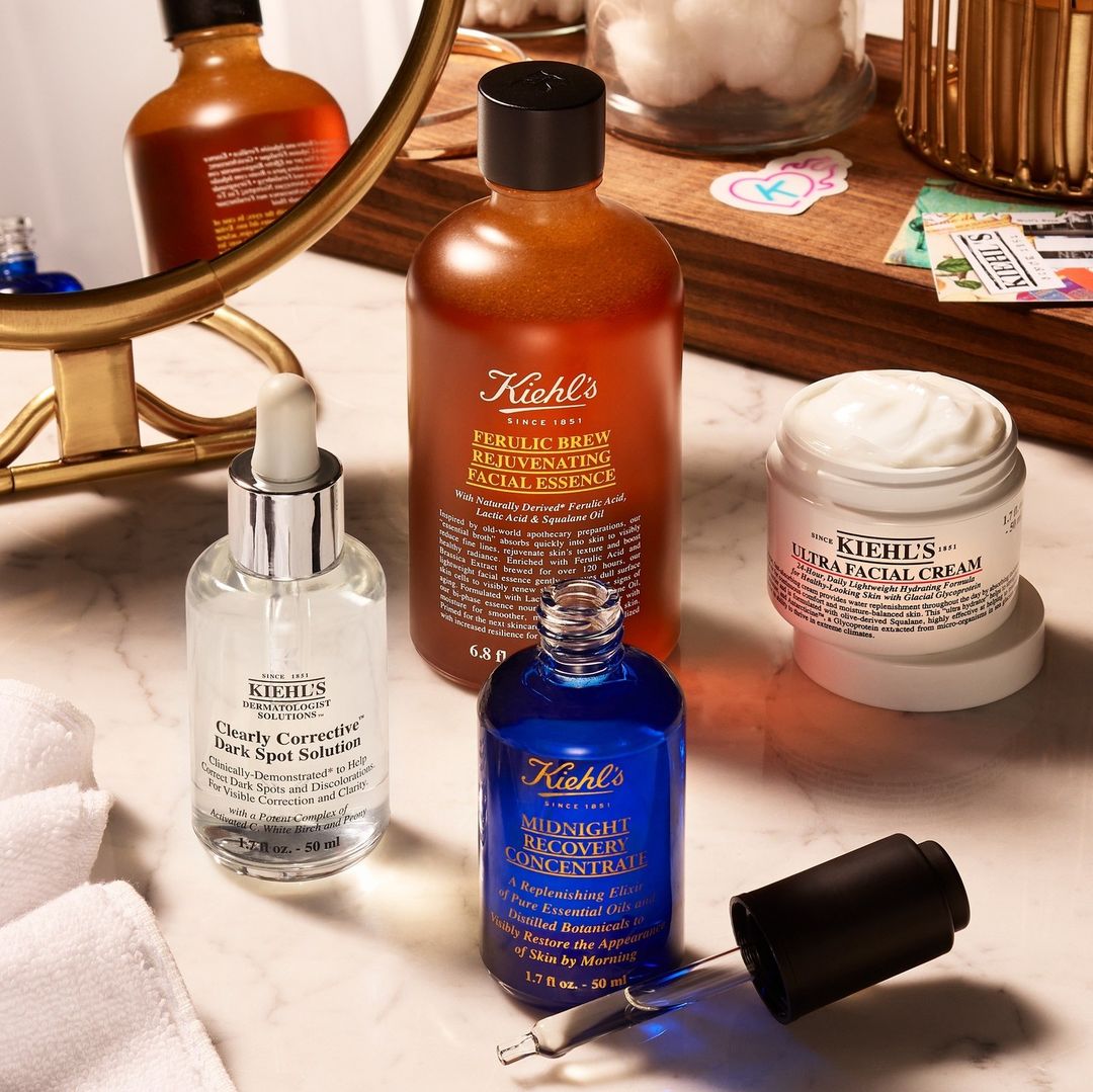 Four Kiehl's skincare products sitting on a vanity in different colours and containers.