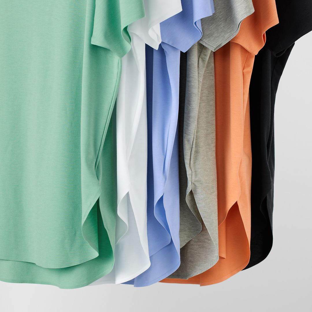 image of six uniqlo t-shirts lined up in succession. the colours are green, white, blue, grey, orange, black