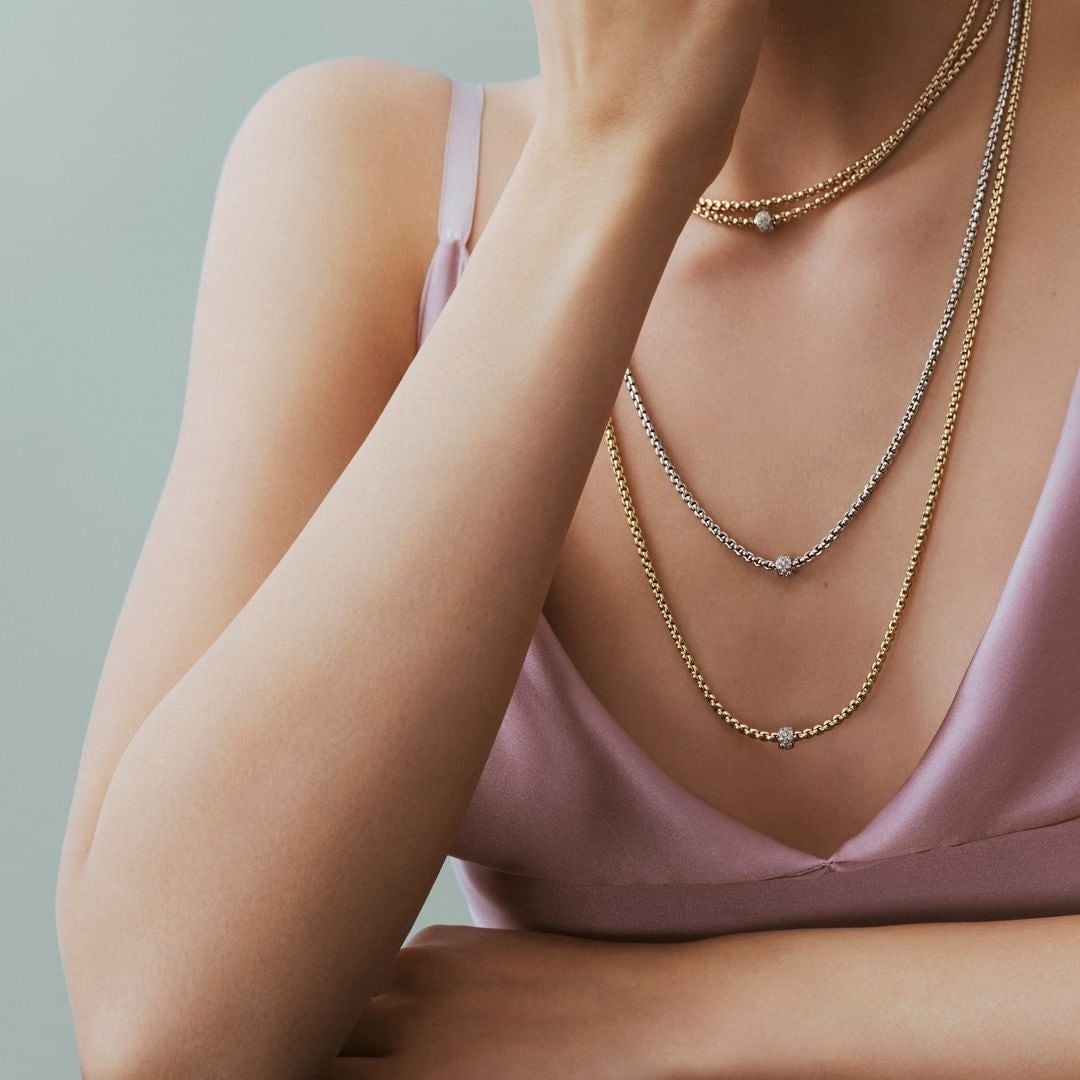 close-up image of a woman wearing layered necklaces from Birks