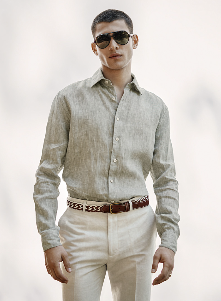 Image of a man wearing a grey linen dress shirt, cream linen pants and sunglasses