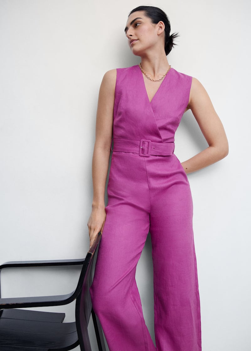 Image of woman wearing a purple linen jumpsuit with a buckle detail