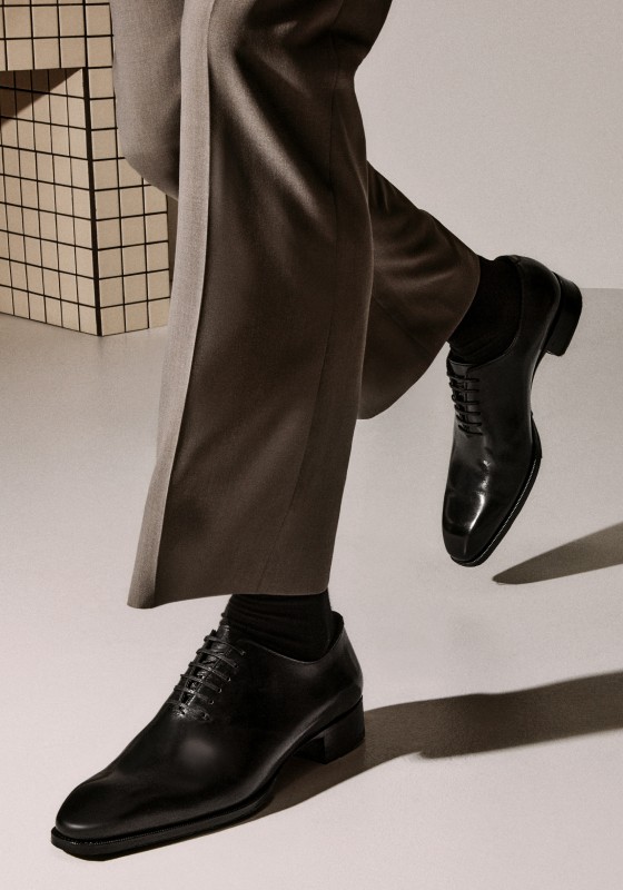 image of a man wearing black leather lace-up dress shoes