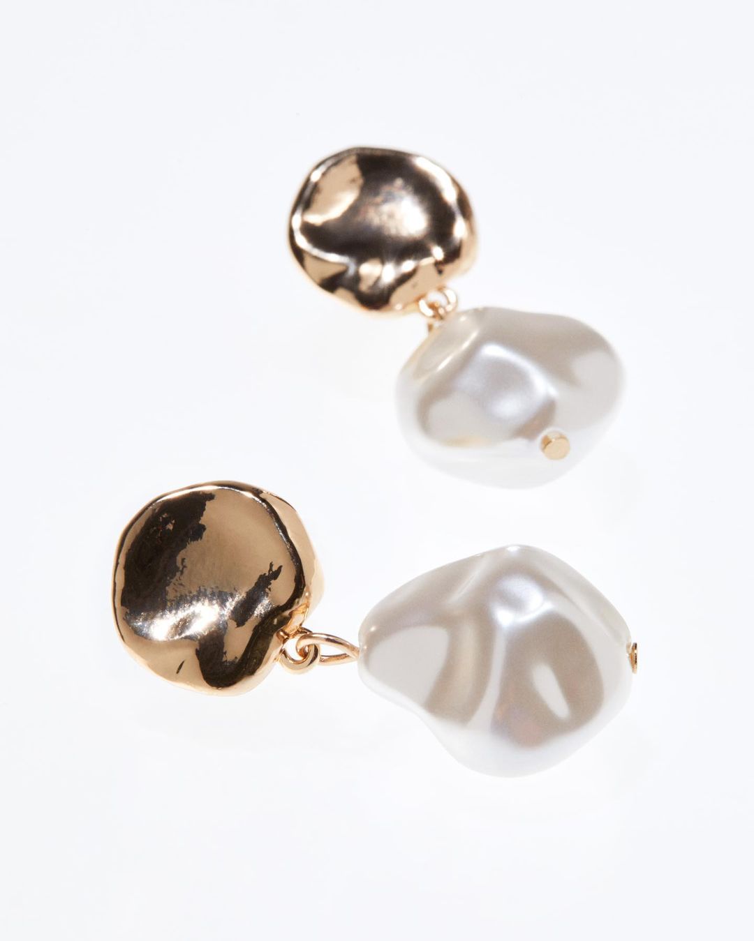 image of gold and pearl earrings against a white backdrop from H&M
