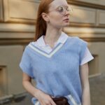 Girl with a blue sweater vest and brown skirt