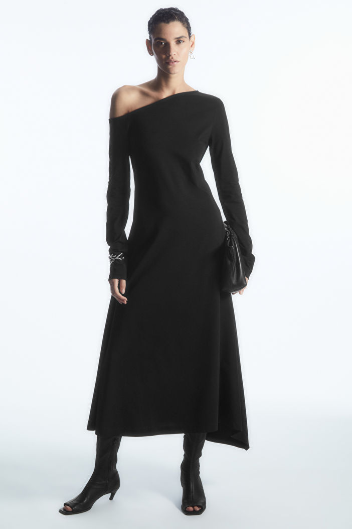 Model wearing a black dress from COS