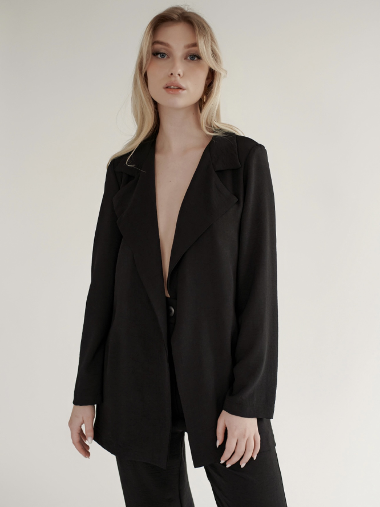 Model wearing a black blazer from RW&CO
