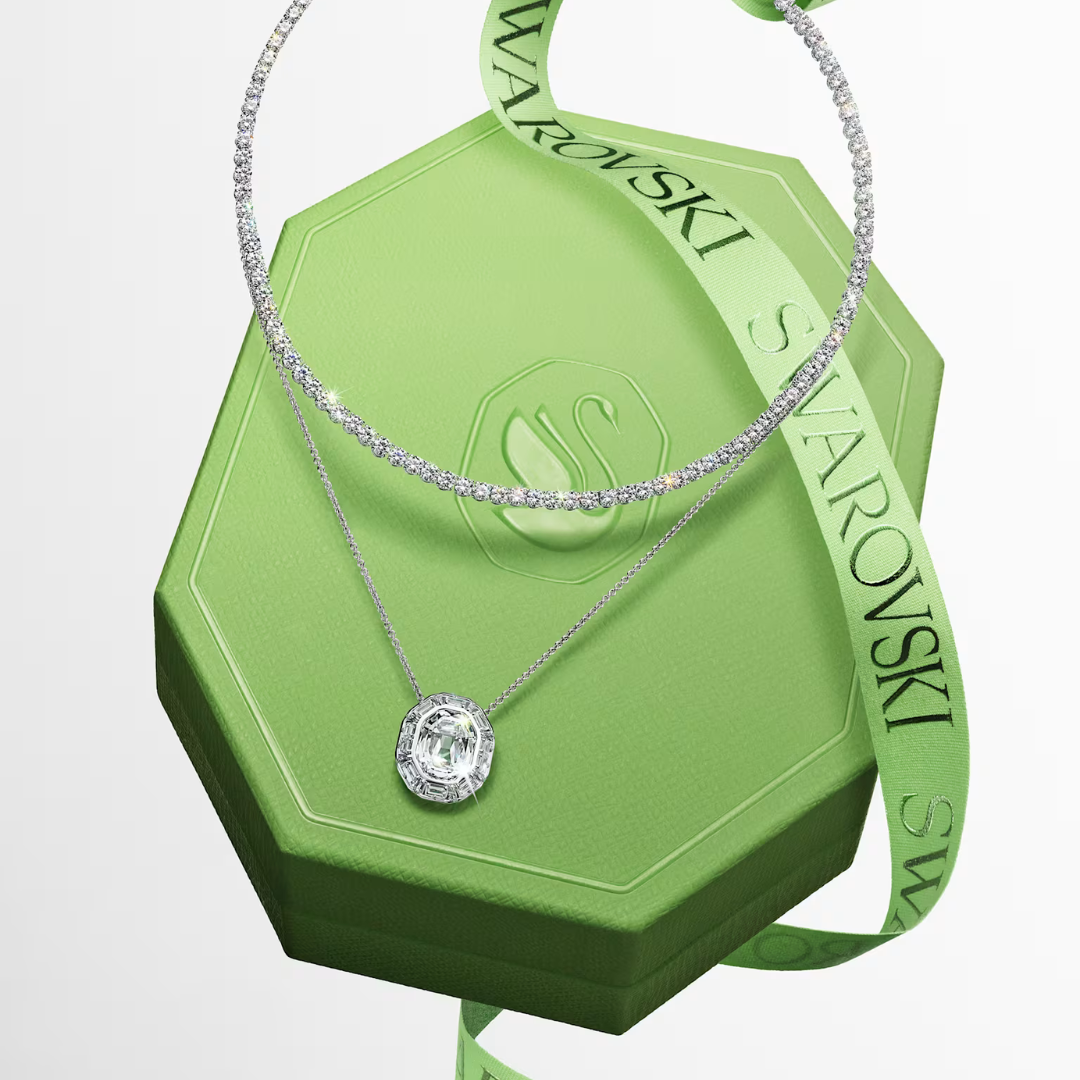 A silver necklace on a green box