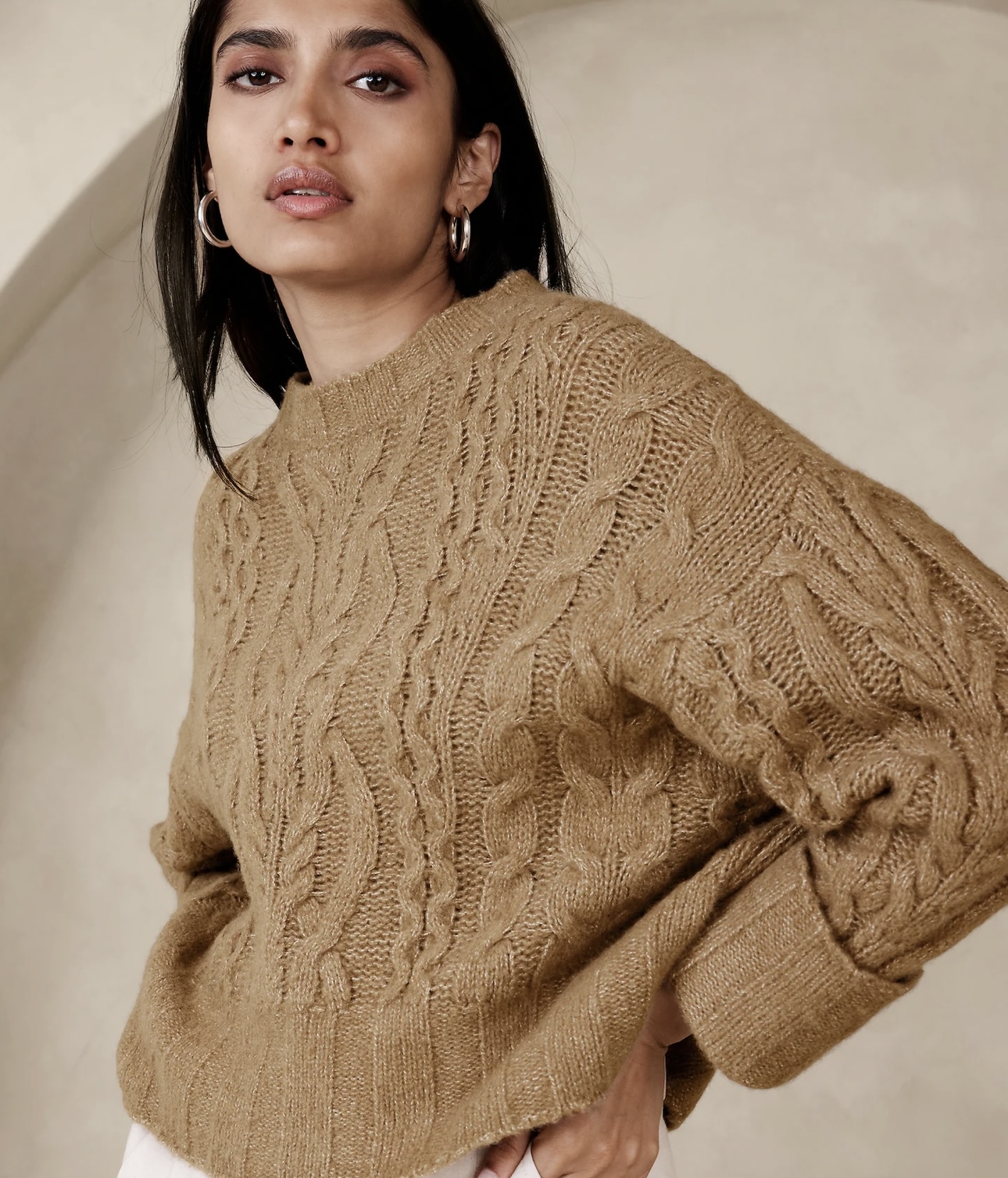 Woman wearing a loose, brown coloured knit sweater