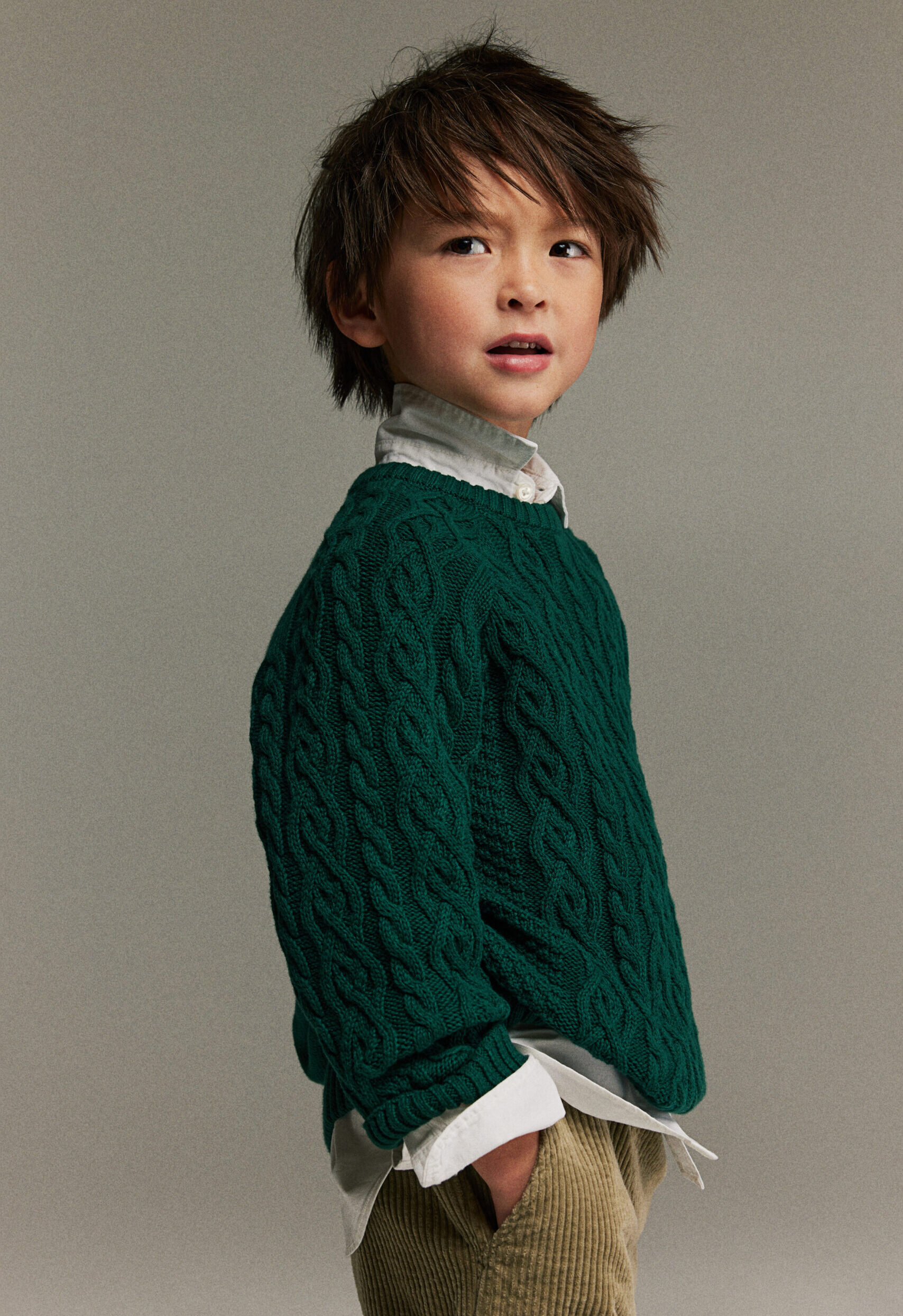 Boy wearing a dark green knit sweater
