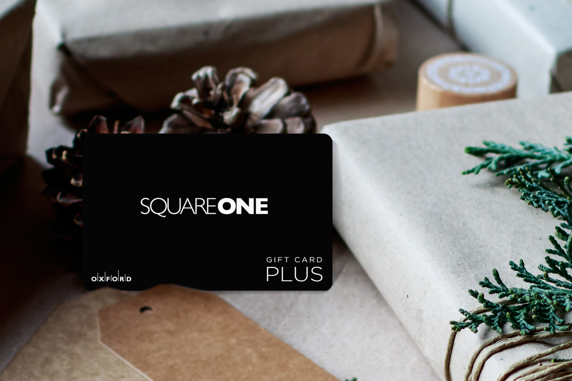 promotional image of a black Square One gift card surrounded by wrapped books in a holiday theme