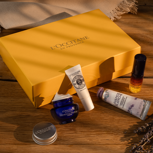 Several bottles of skin care products on a table with a yellow gift box