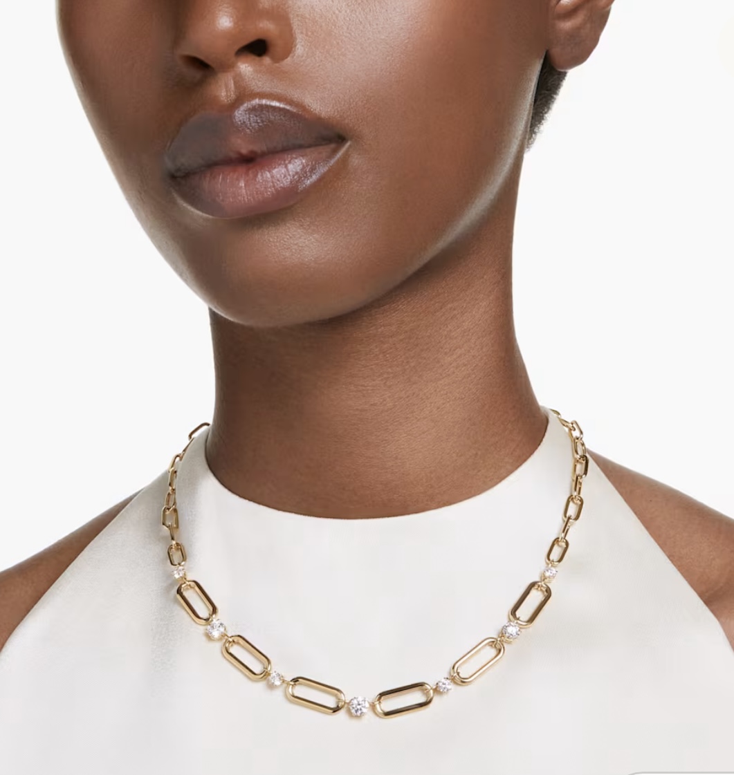 A woman wearing a gold chain necklace