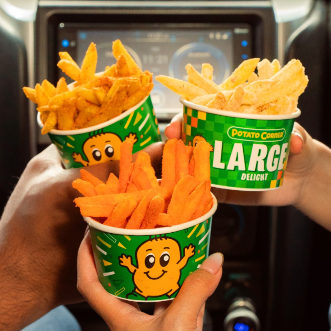Hands holding up containers of french fries