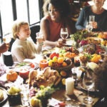 People sitting around a meal at a dining table and laughing.