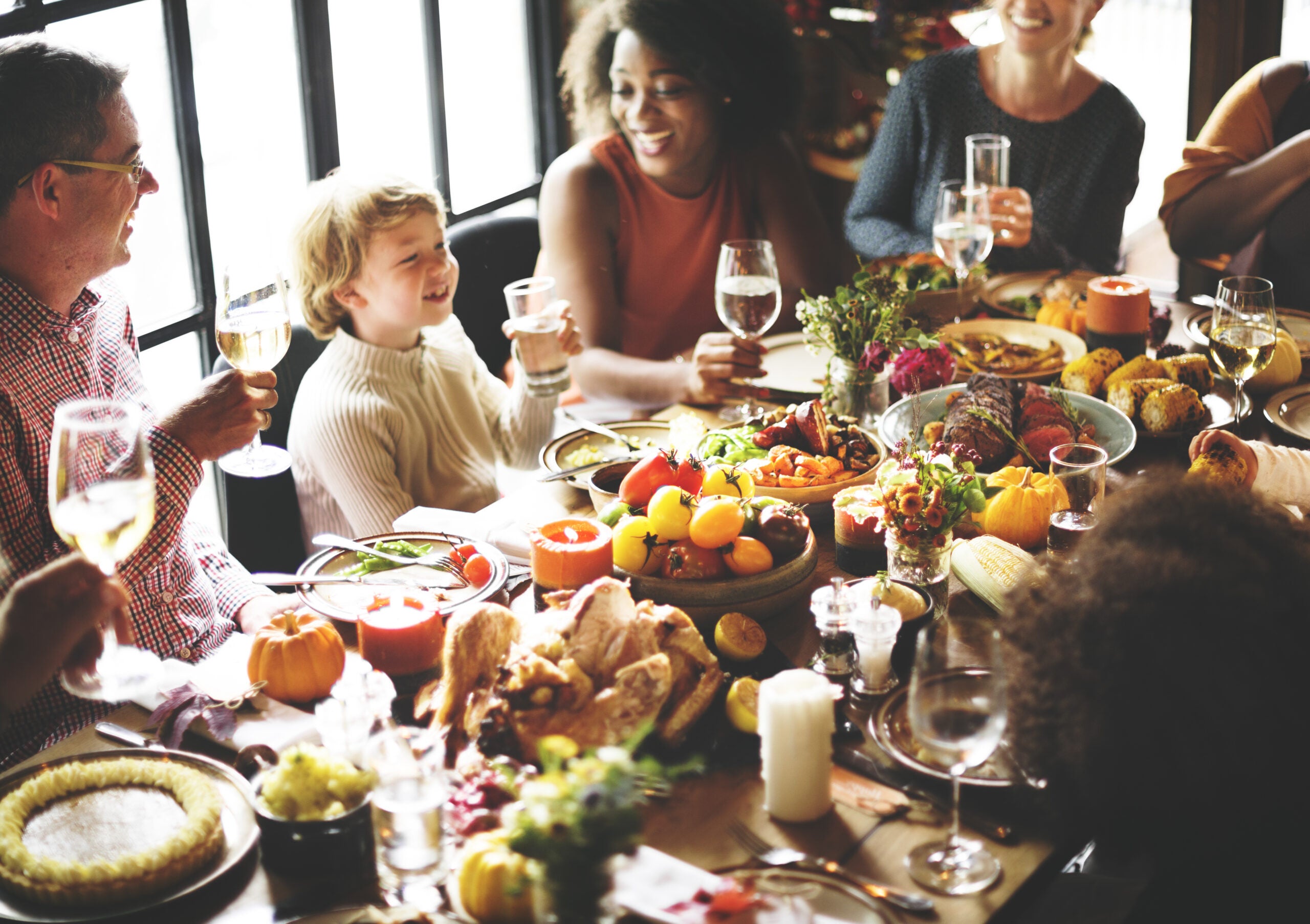 People sitting around a meal at a dining table and laughing.