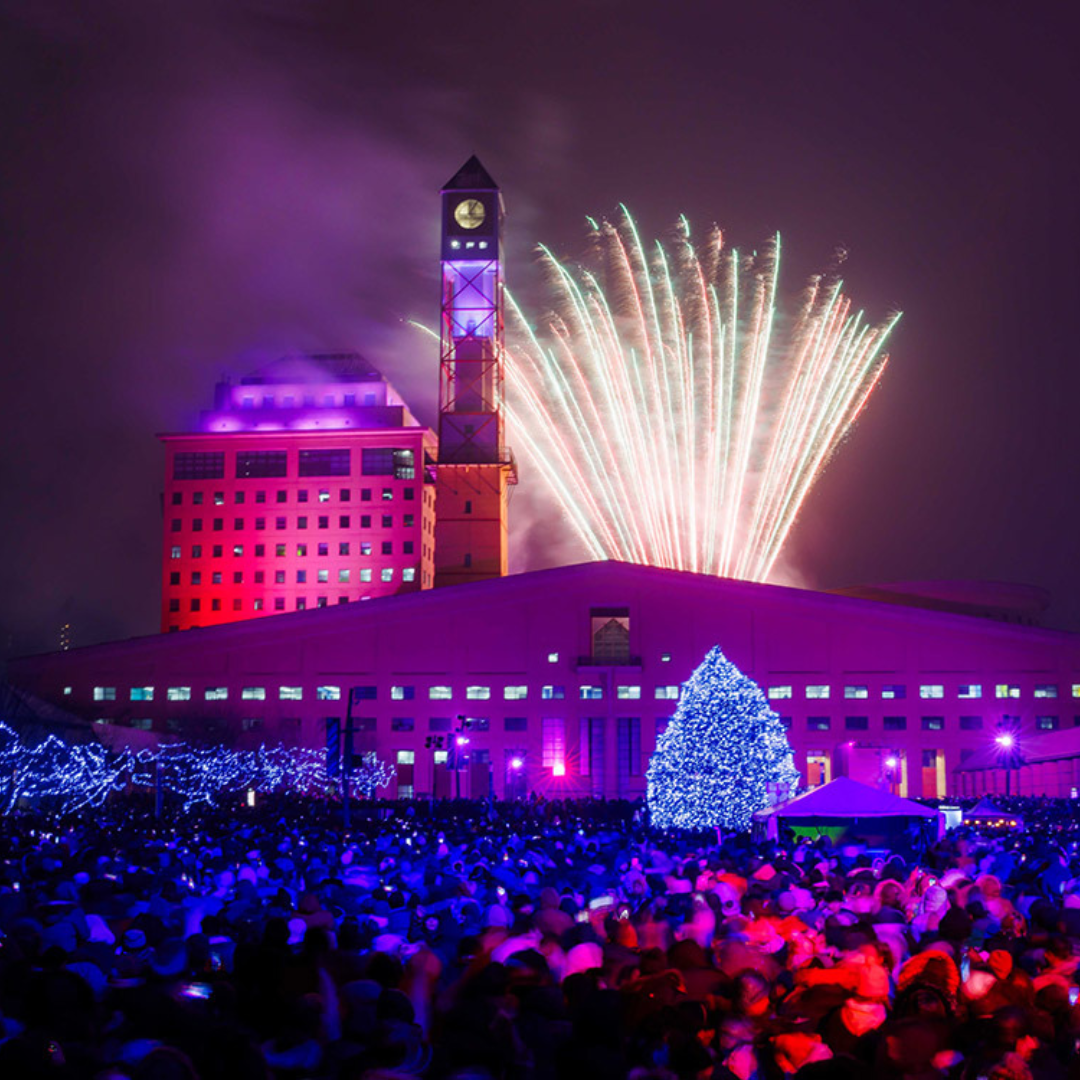 A fireworks display taking place in front of a large crowd