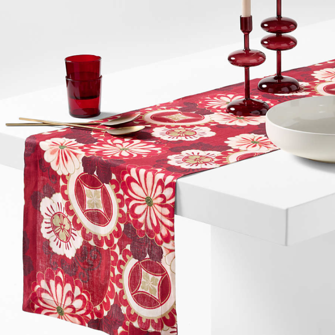 A red table runner with a bold floral design.