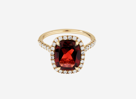 A gold ring with a large red diamond.