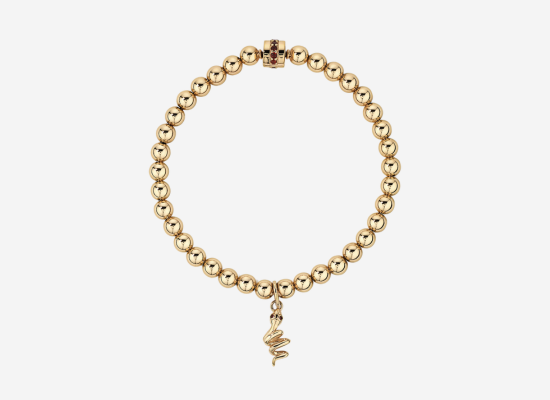 A gold bracelet with a snake pendant.