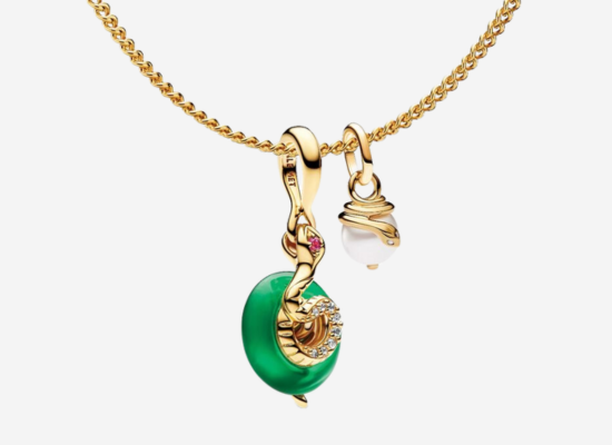 A gold bracelet with a jade pendant hanging off it.