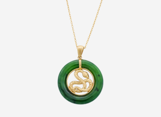 A jade pendant with a gold snake in the centre of it hanging on a gold chain.