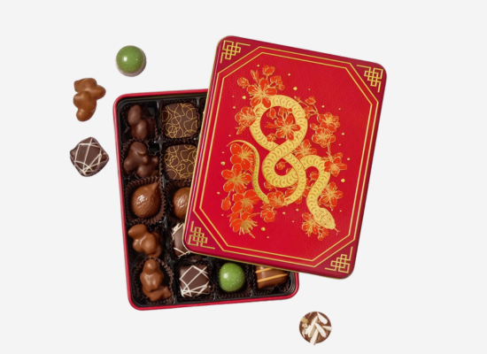 A red box of chocolates with a gold snake motif on the cover.