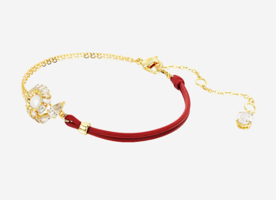 A gold bracelet with red roping.