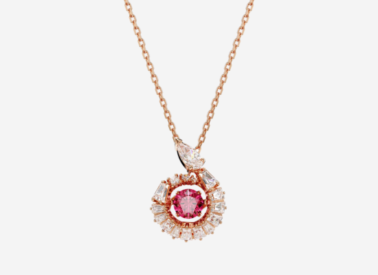 A red and gold diamond pendant on a gold chain.