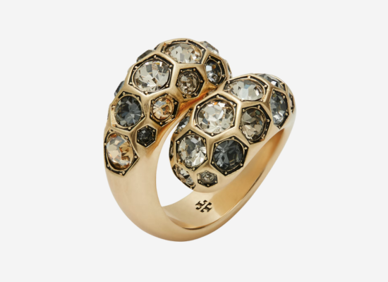 A gold ring covered with an assortment of black and white diamonds.