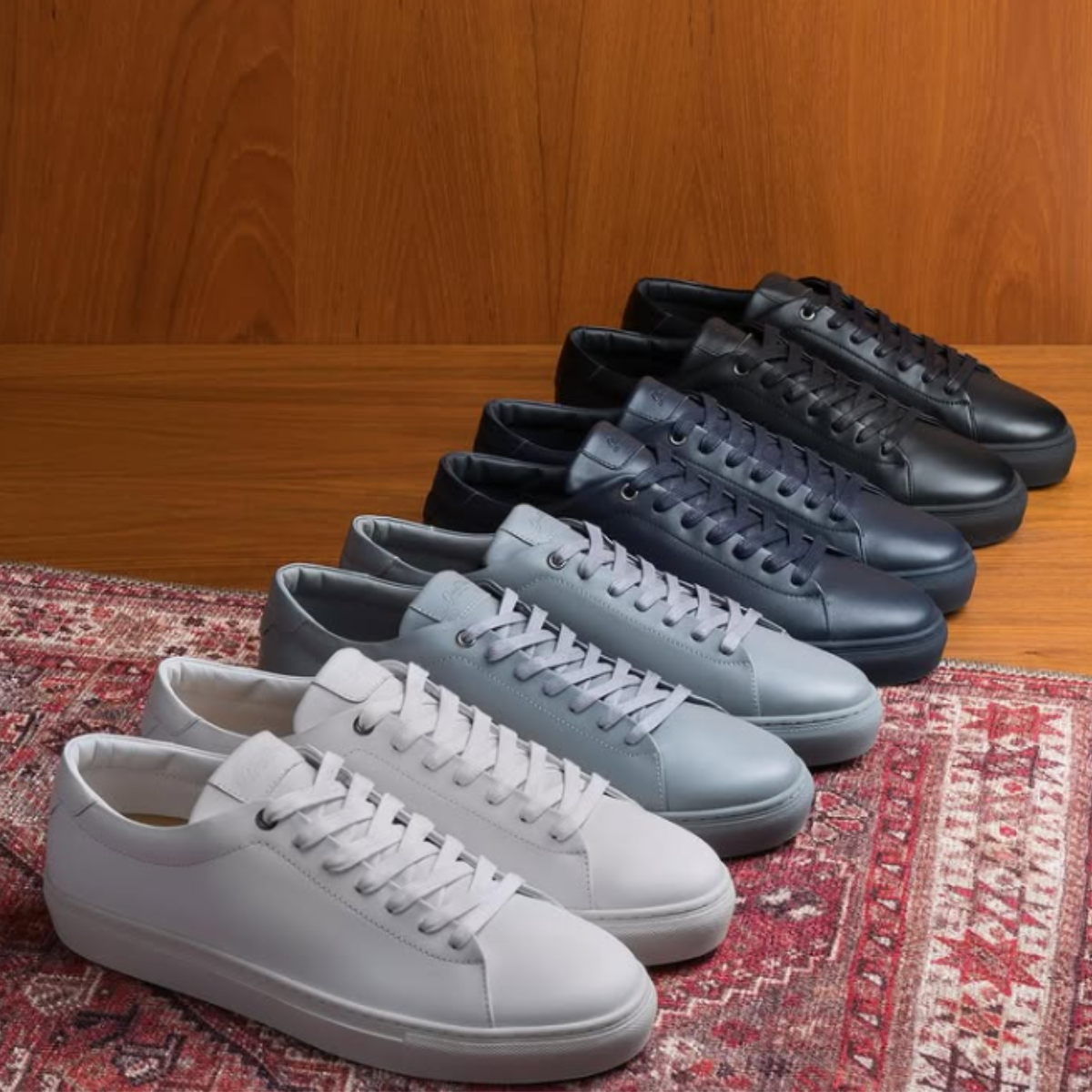 Four pairs of shoes displayed on a carpet.