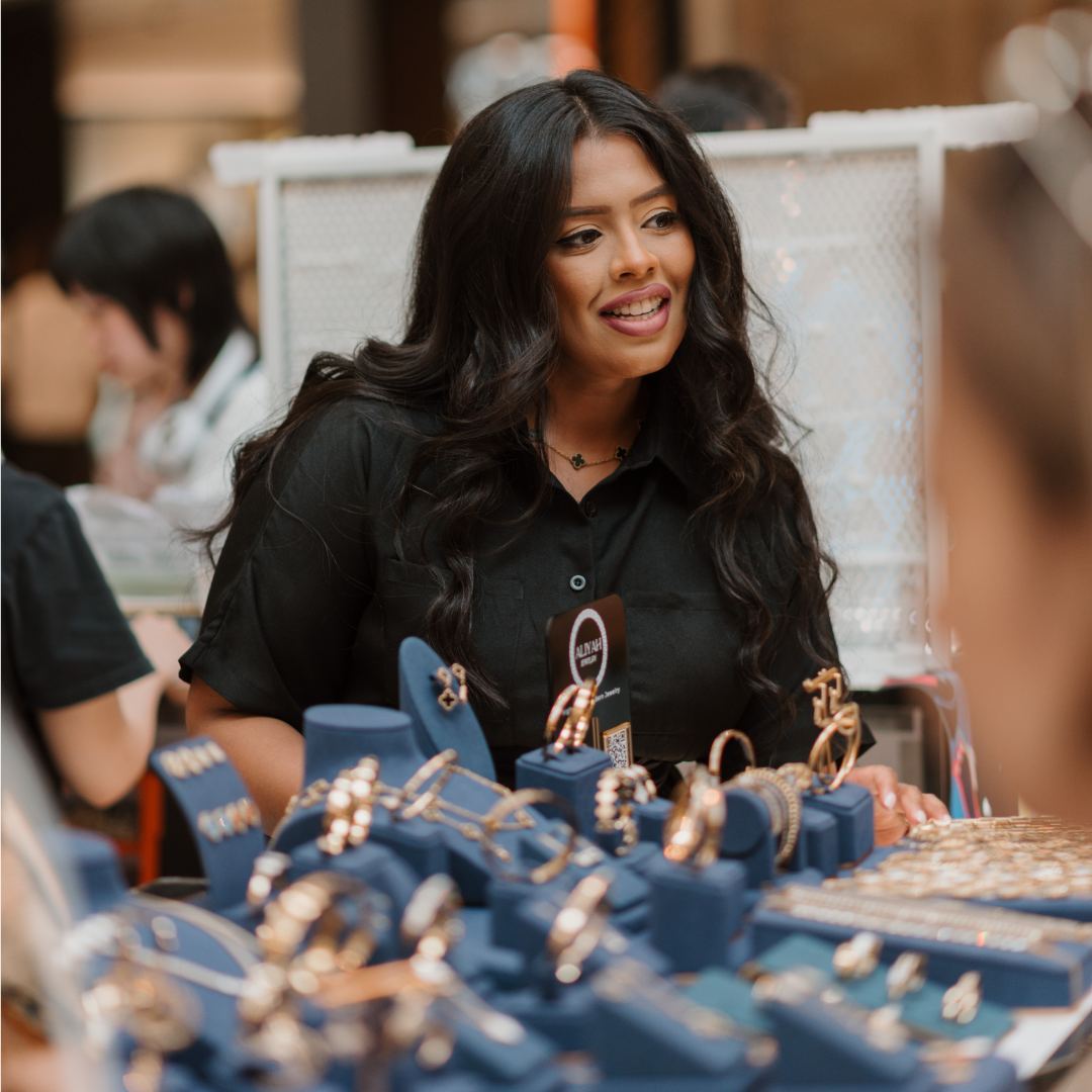 A woman showcasing her products at a market.