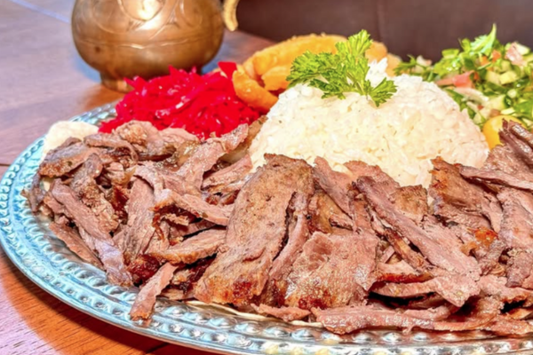 A plate of meat, rice and vegetables.