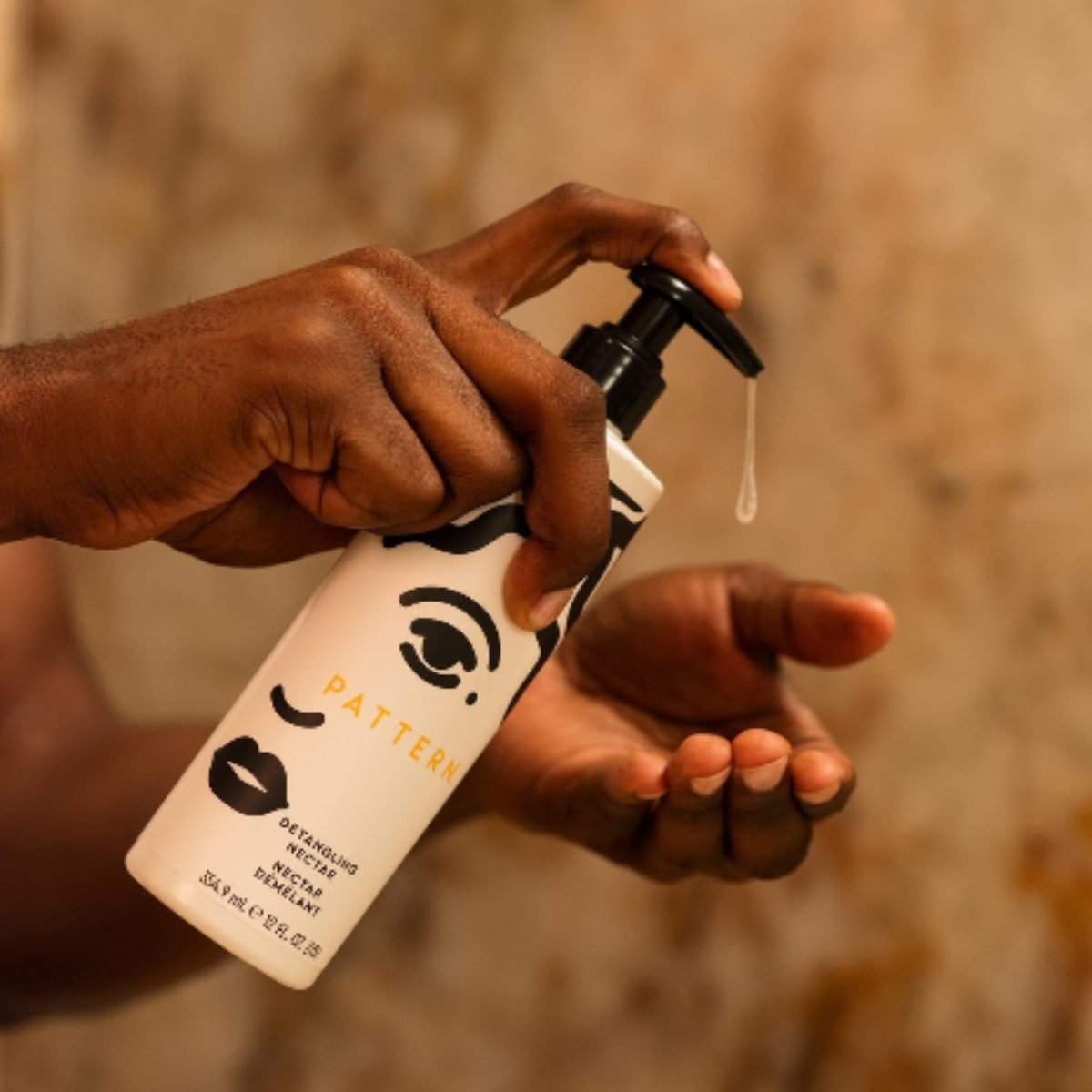 A person pumping soap from a container into their hand.