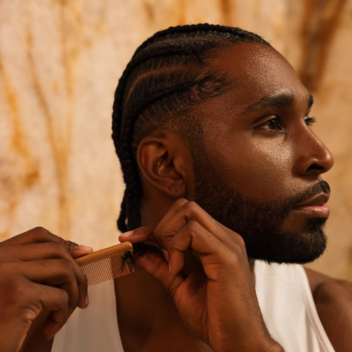 A man combing his braids.