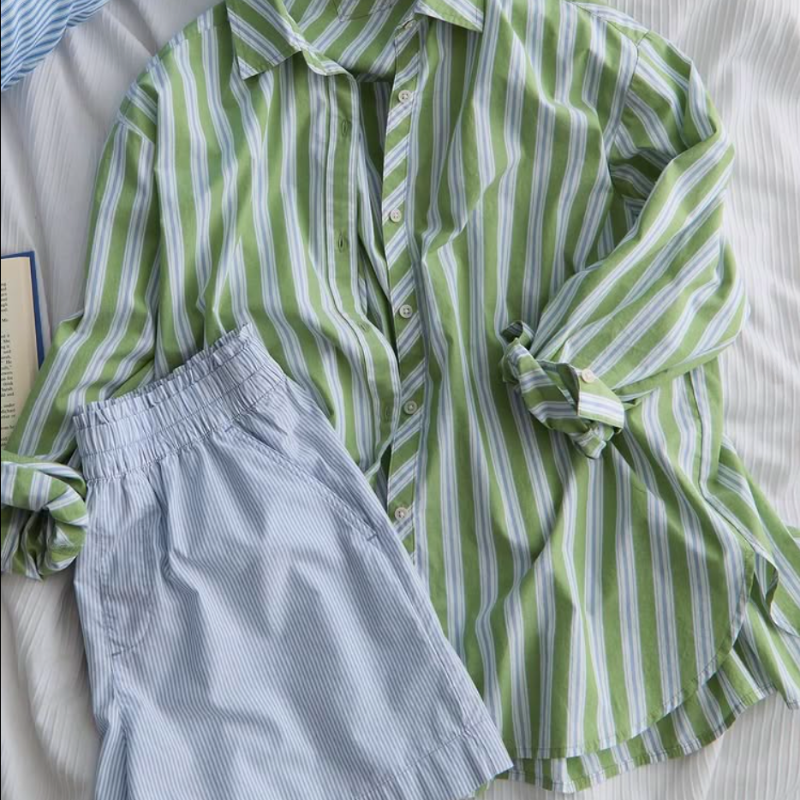 A light green, striped button up shirt and a light grey striped pair of shorts.