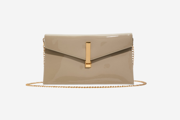 A glossy tan coloured hand bag with a gold chain.