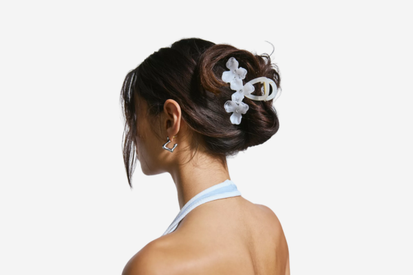 A woman's hair tied up with a floral hair clip.