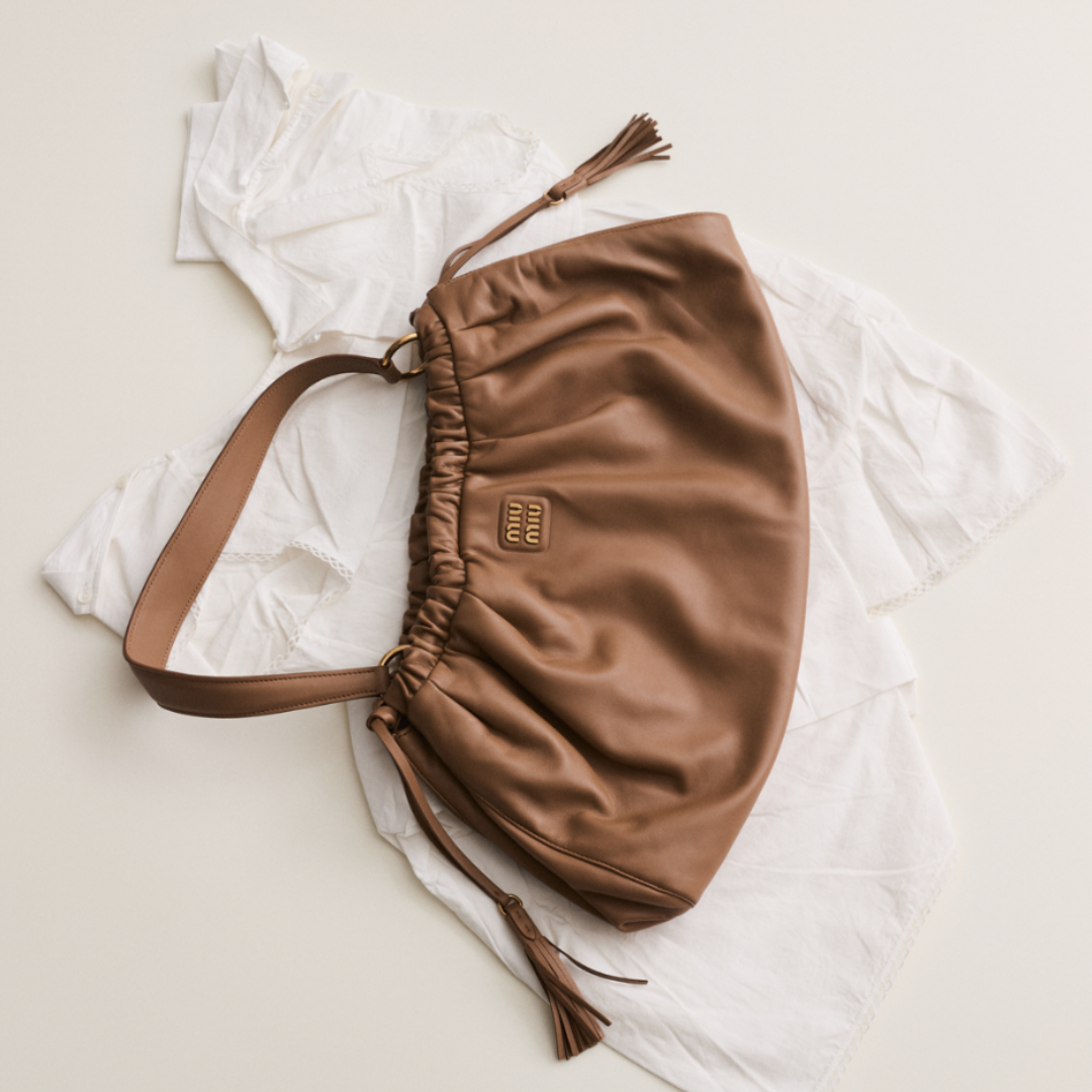 A brown Miu Miu bag and a white dress