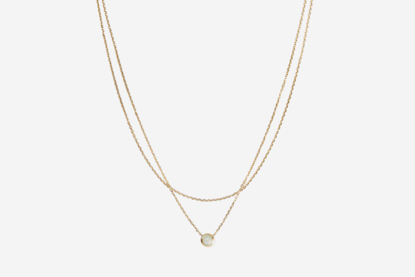 A gold necklace with a small pearl pendant.