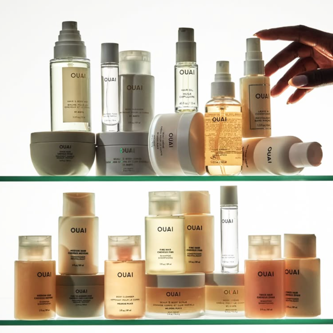 An assortment of products from OUAI on a glass shelf.