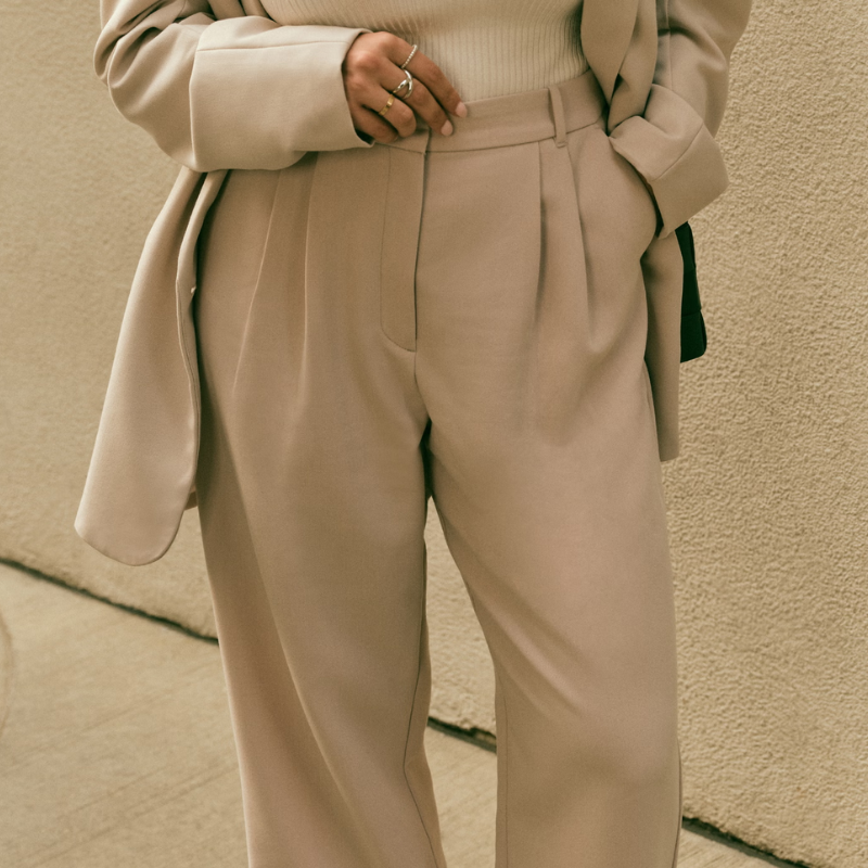 A person wearing a beige coloured suit.