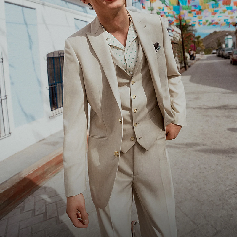 A man wearing a light coloured linen 3-piece suit.