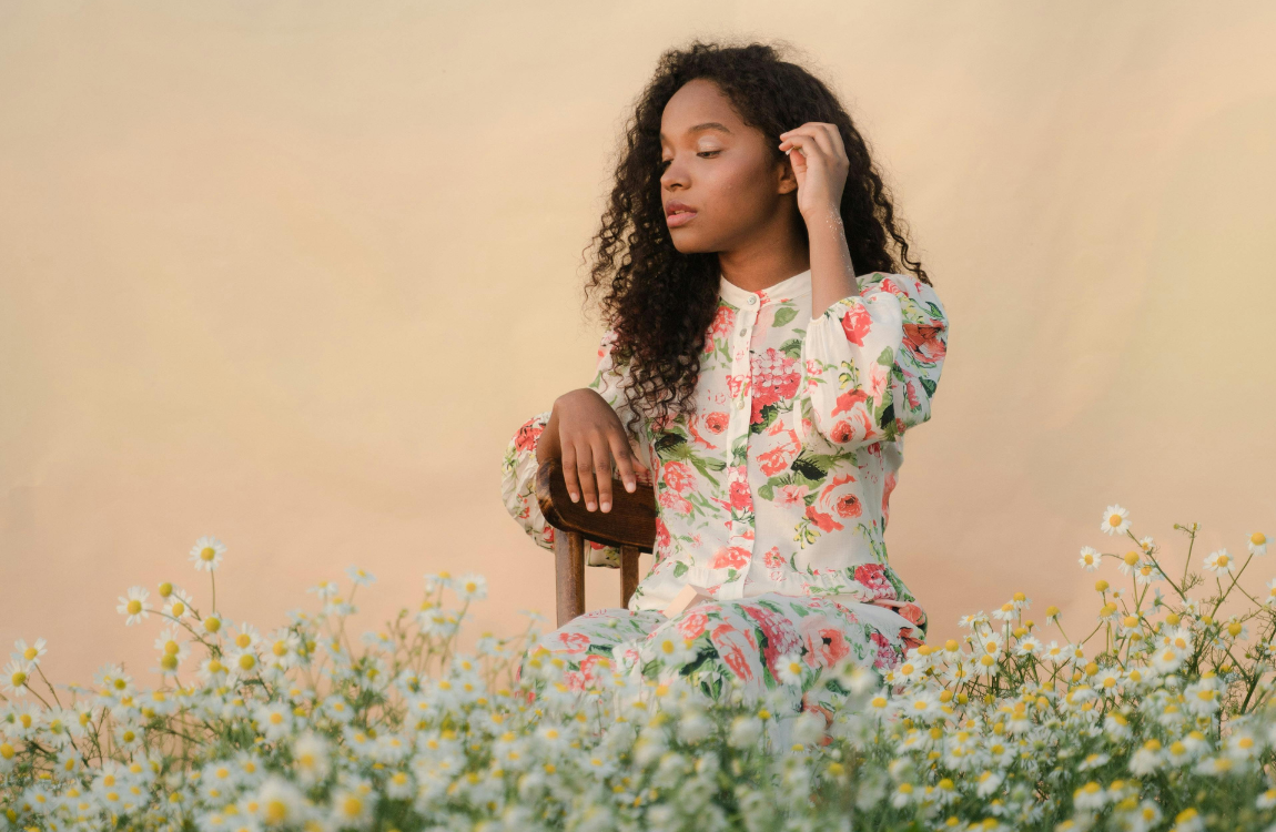 A woman sitting in a field of daffodils.