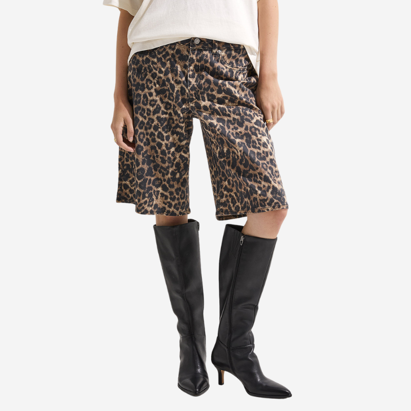 A woman wearing baggy leopard print shorts and black leather boots